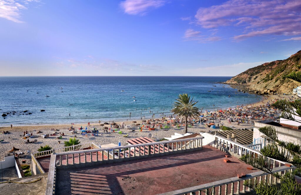 Relaxing summer beach view in Tanger, Morocco with vibrant coastal scene and clear blue sea.