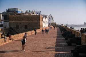 Scenic view of Essaouira fort showcasing people walking along the historic cannons and walls.