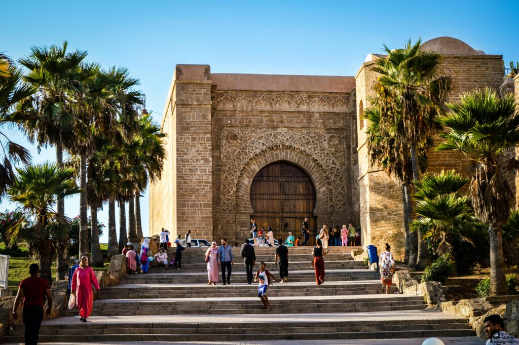 Tourists at Bab Oudaia Gate, Rabat, enjoying a sunny day by the iconic landmark.