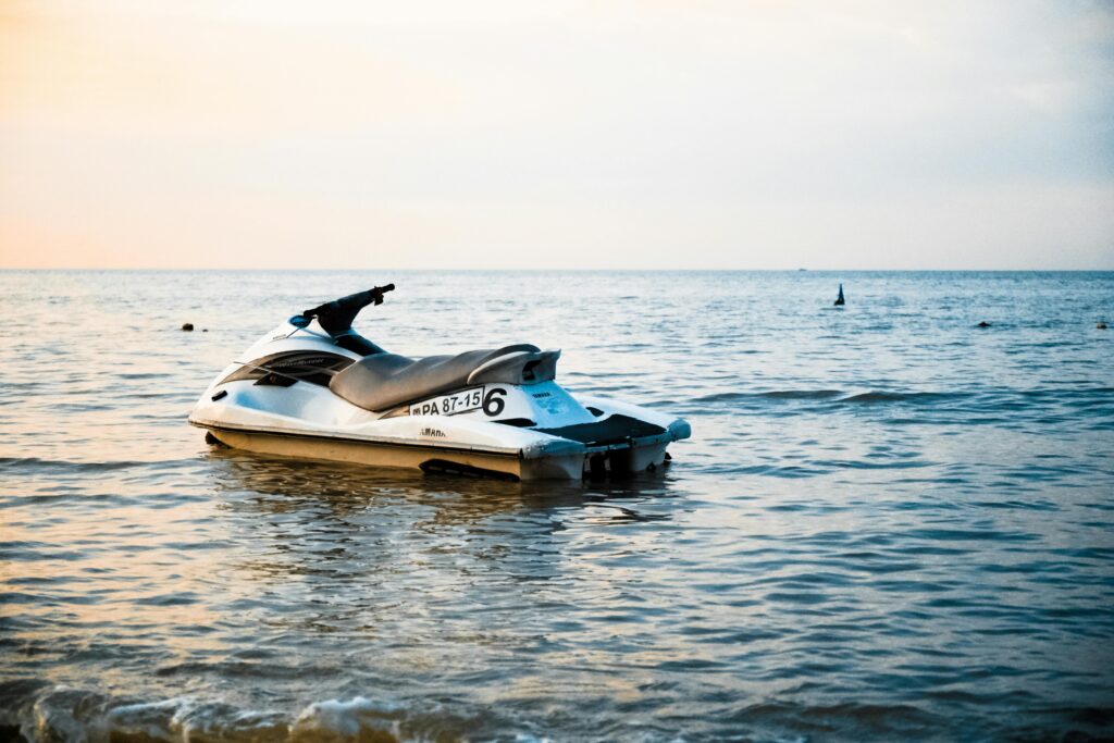 A lone jet ski rests on calm ocean waters during a serene sunset. Perfect for travel and leisure themes.